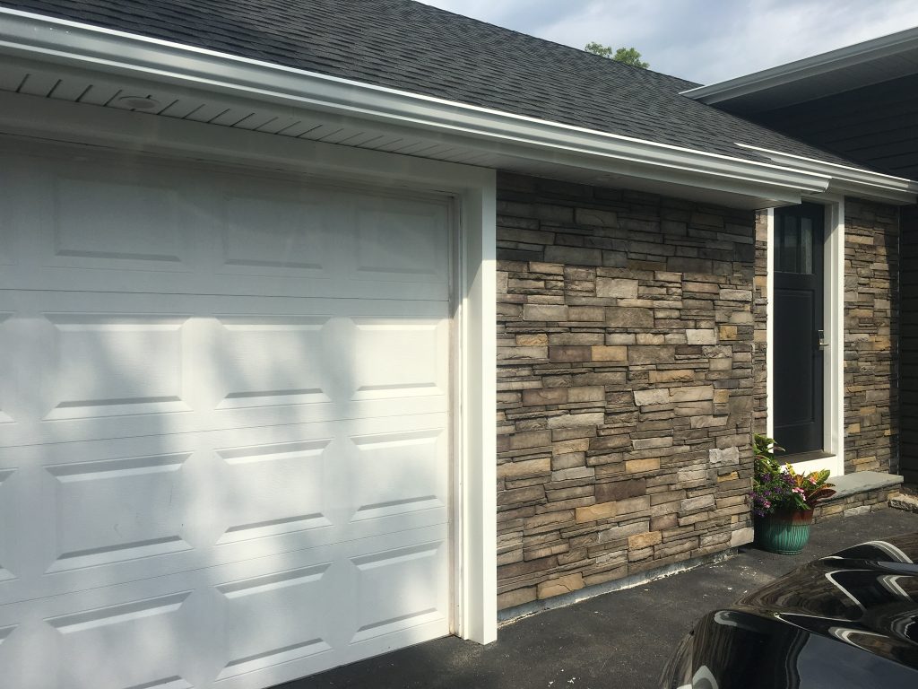 Cultured stone column and siding detail on a finished Long Island home exterior.